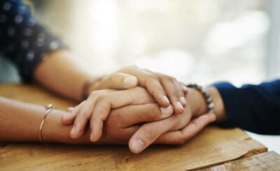 Closeup shot of two unrecognizable people holding hands in comfort